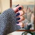 Hand with medium-length nails painted in glossy dark navy from Dark & Moody Gel Polish Set for a long-lasting gel mani thumbnail