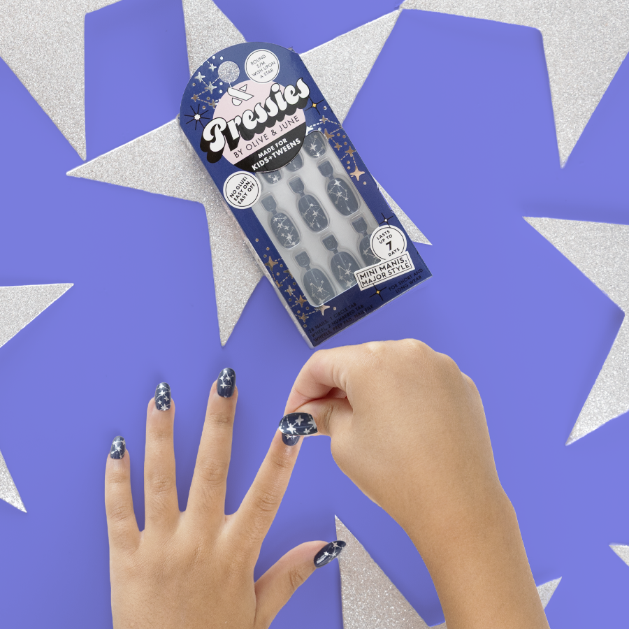 Wish Upon A Star - Pressies | Short Medium | Round showing hands applying navy blue press-on nails with silver star constellation nail art