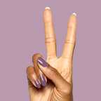 Hand with glossy Cardigan gel polish manicure on medium-length nails showing peace sign against mauve background