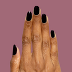 Hand with deep dark plum Covet gel polish manicure on medium-length natural nails against muted plum background