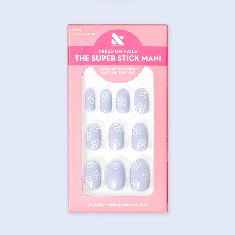 Floral Doodle | Short | Round - Tab Press-On nails in pastel blue with white floral doodles displayed in retail packaging