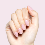 Hand with Glossed sheer lavender-pink gel polish manicure in glossy finish on natural nails against pale pink background