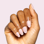 Hand with Glossed sheer lavender-pink gel polish manicure on natural nails against soft light pink background