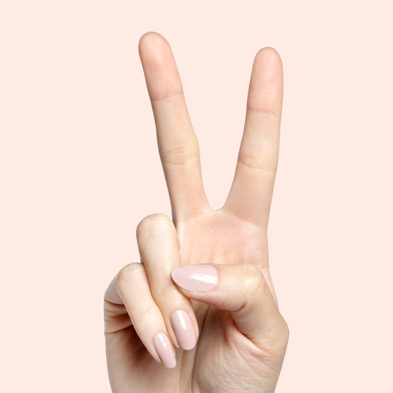 Hand with almond-shaped nails painted in Kitten neutral greige polish showing a soft, polished mani look
