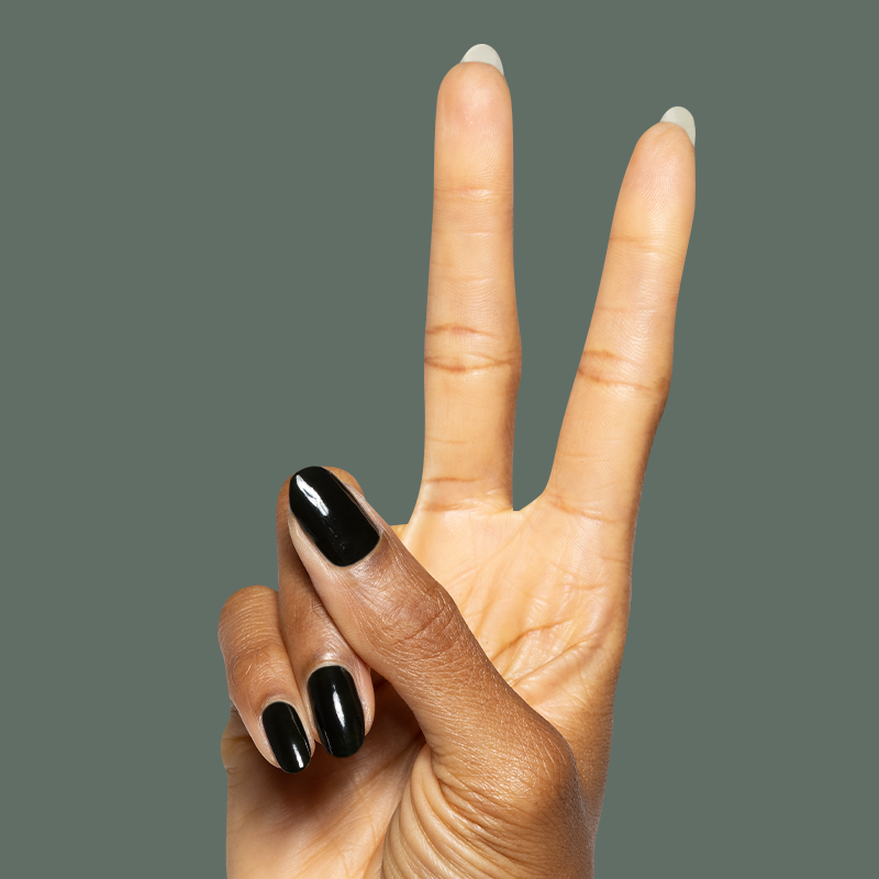 Hand showing peace sign with Latenight ultra-dark olive green quick dry gel polish manicure on natural nails against muted green background