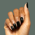 Hand displaying glossy Latenight quick dry polish manicure on natural nails against muted olive green background