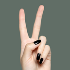 Hand showing peace sign with Latenight ultra-dark olive green quick dry polish manicure on natural nails against muted green background