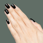 Hand with glossy black manicure on natural nails showcasing Latenight quick dry polish against muted olive background