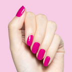 Hand with glossy Leotard hot magenta polish manicure on medium-length rounded nails against pink background