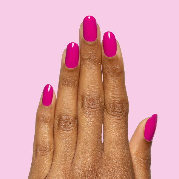 Hand with smooth glossy Leotard gel polish manicure on rounded nails against solid light pink background