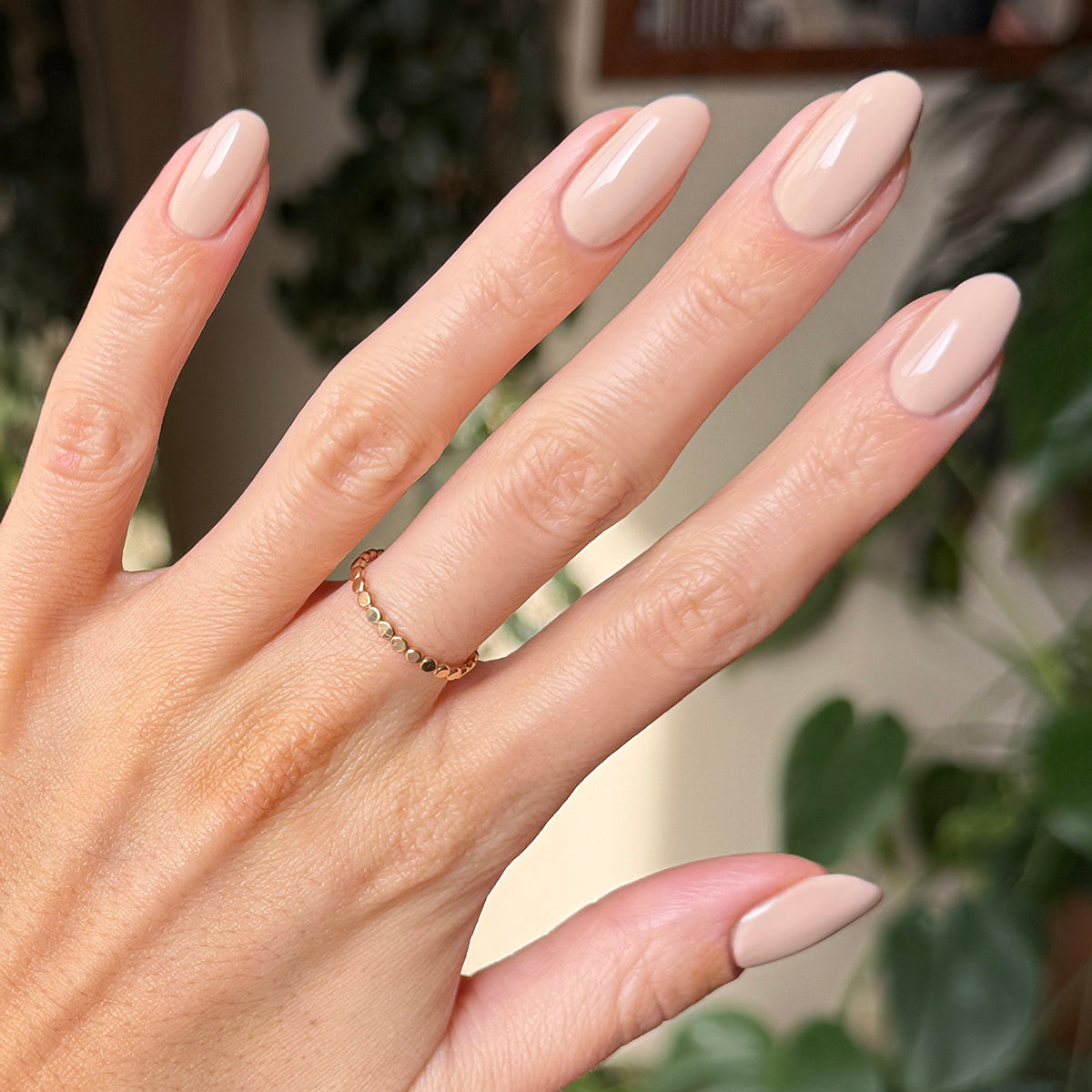 Hand with medium-length nails in soft neutral toasted cream shade using Line Dancing Boots polish for a refined mani