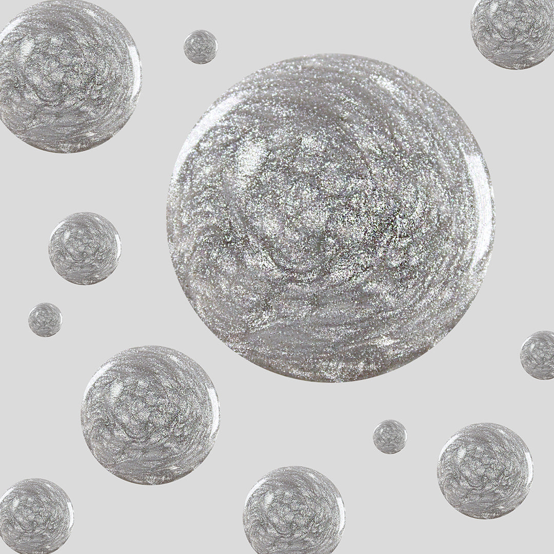 Glossy silver glitter polish droplets in Midnight Disco showing ultrafine shimmer on a neutral gray background