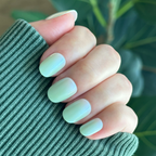 Hand with Minty Shimmer | Extra Short | Round - Tab Press-On nails in soft mint green gradient with subtle shimmer finish manicure