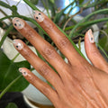 Valentine Mini Polish Set nails with sheer nude polish and black heart and silver glitter accents for a stylish mani look thumbnail