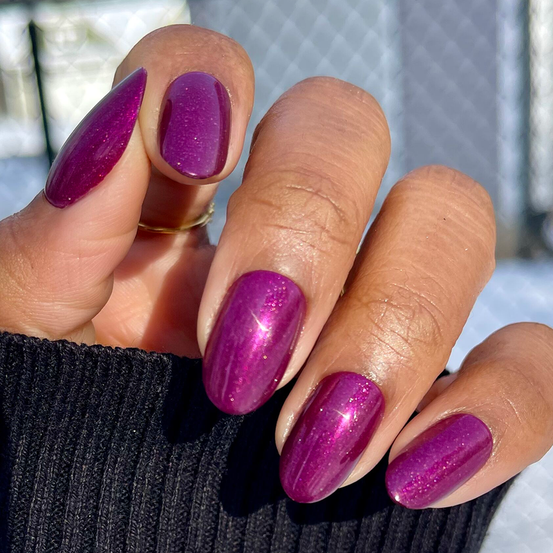 Hand with deep purple shimmer nails wearing the Super Stick Special Effects Press-On Set for easy at-home mani