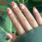 Puffy Bubble Flowers - Press-On | Short | Round white nails with raised orange floral details on hand over green leaves background
