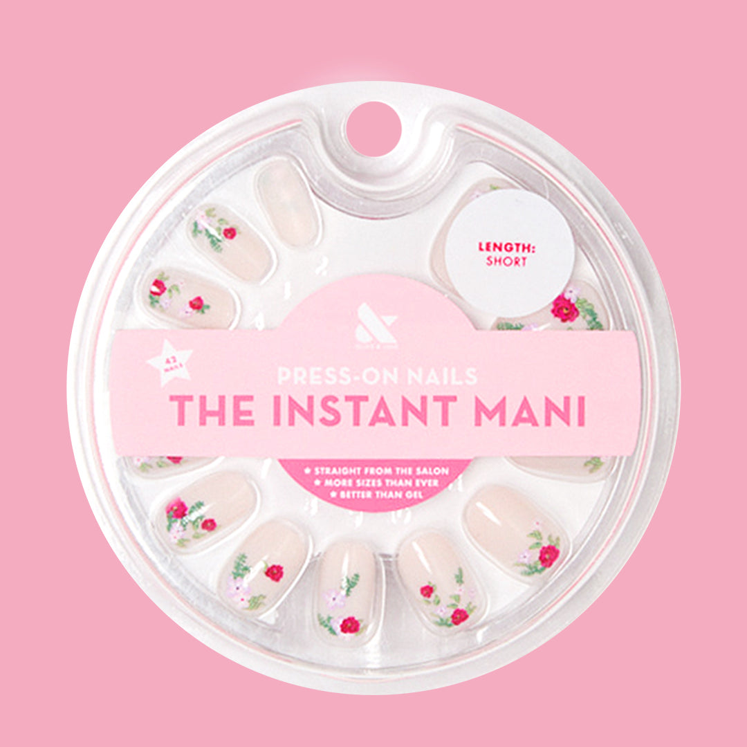Rose Bouquets - Press-On | Short | Squoval showing squoval press-on nails with red rose bouquet designs in clear packaging on pink background