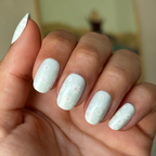 Teal Chrome Flower Shower - Press-On | Short | Round with pale teal nails and white daisy floral mani on hand indoors