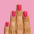 Hand with vibrant hot pink nails polished with XOXO long-lasting nail polish on a bright pink background