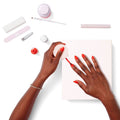 Hands applying bright red polish with manicure tools displayed on white background for Gift The Mani System thumbnail
