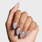 Hand showing nails painted with Exclamation Point silver holographic glitter polish for a sparkling at-home mani