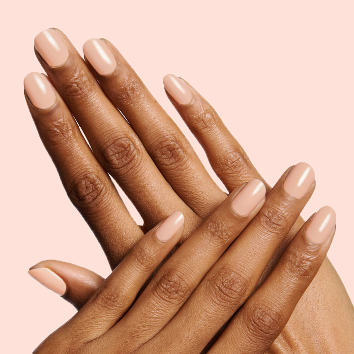 Hands with nails polished in Olive and June JO showing a smooth dusty apricot shade for a stylish mani look