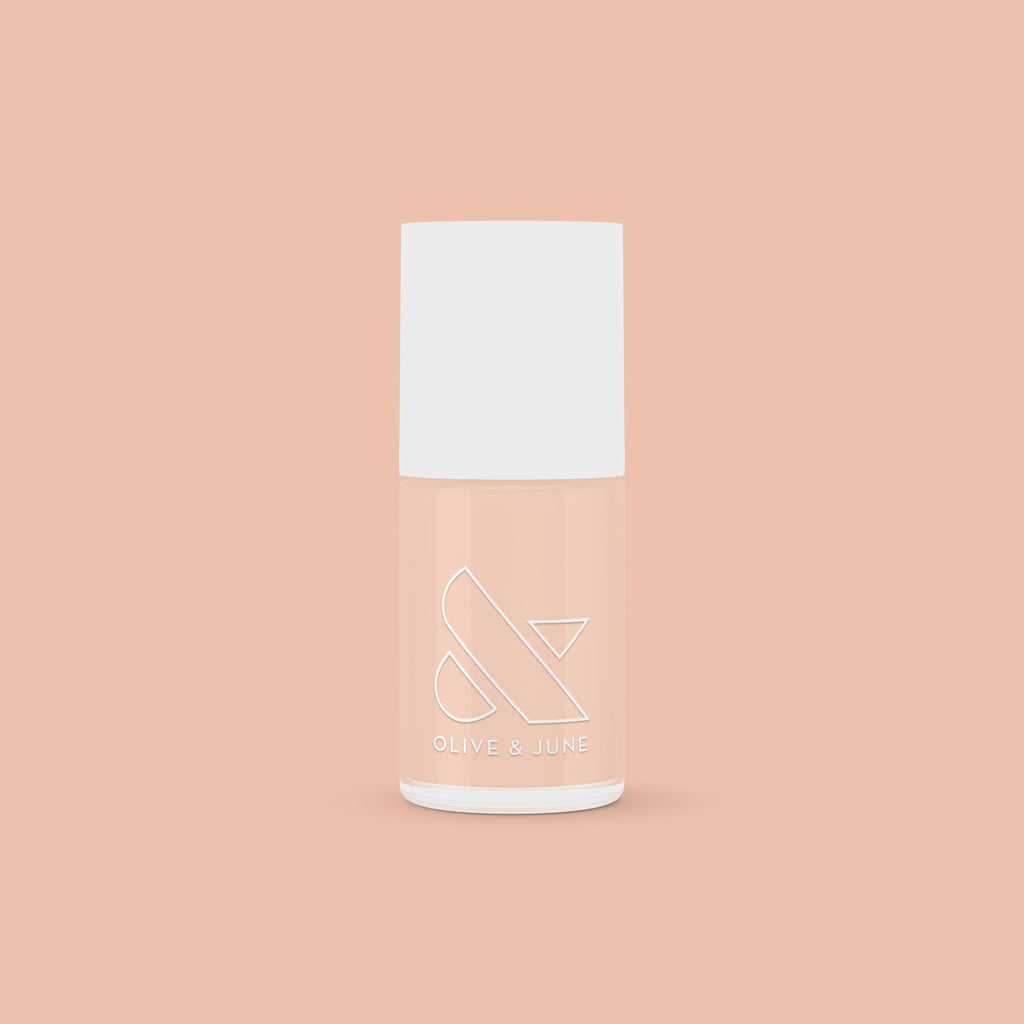 KAG nail polish bottle in neutral peachy pink shade on matching peach background for a fresh mani or pedi