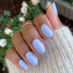 Hand showing nails painted with BP, an icy pastel blue gel polish perfect for a fresh at-home manicure