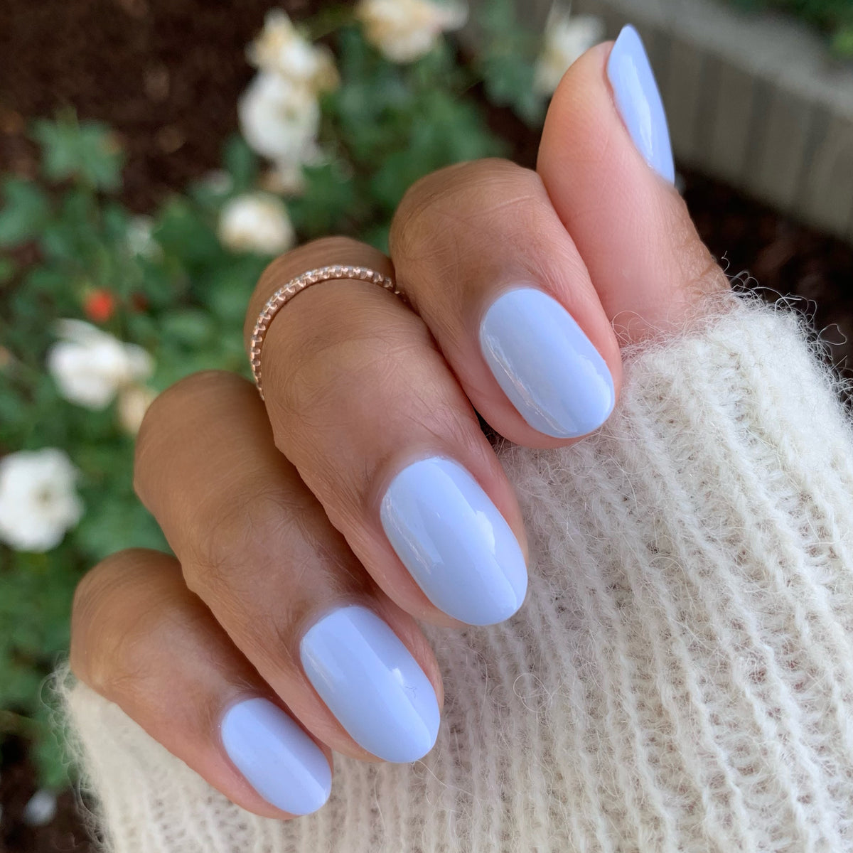 Hand showing nails painted with BP, an icy pastel blue gel polish perfect for a fresh at-home manicure
