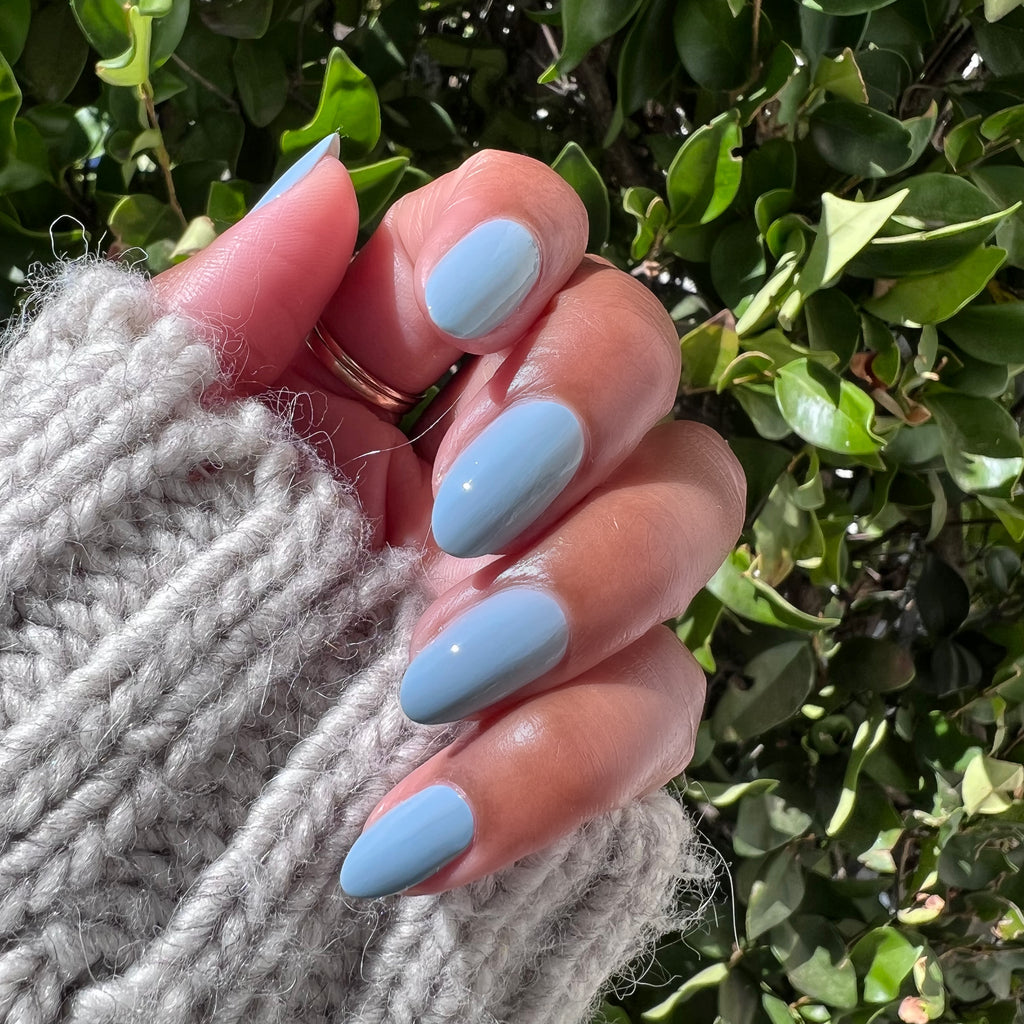 Hand with nails painted in Vintage blue polish showing a glossy, quick dry manicure perfect for at-home nail care