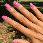 Hand with nails polished in Grateful & Kind pure pink gel polish for a vibrant and long-lasting mani by Olive and June