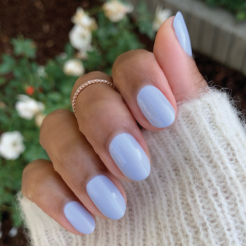 Hand with nails painted in BP, a pastel icy light blue gel polish for a smooth and lasting at-home manicure