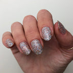 Fingernails coated in Exclamation Point silver holographic glitter polish for a dazzling and long-lasting at-home manicure