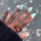 Hand with nails painted in pastel green Minty polish showcasing a fresh, long-lasting manicure by Olive and June