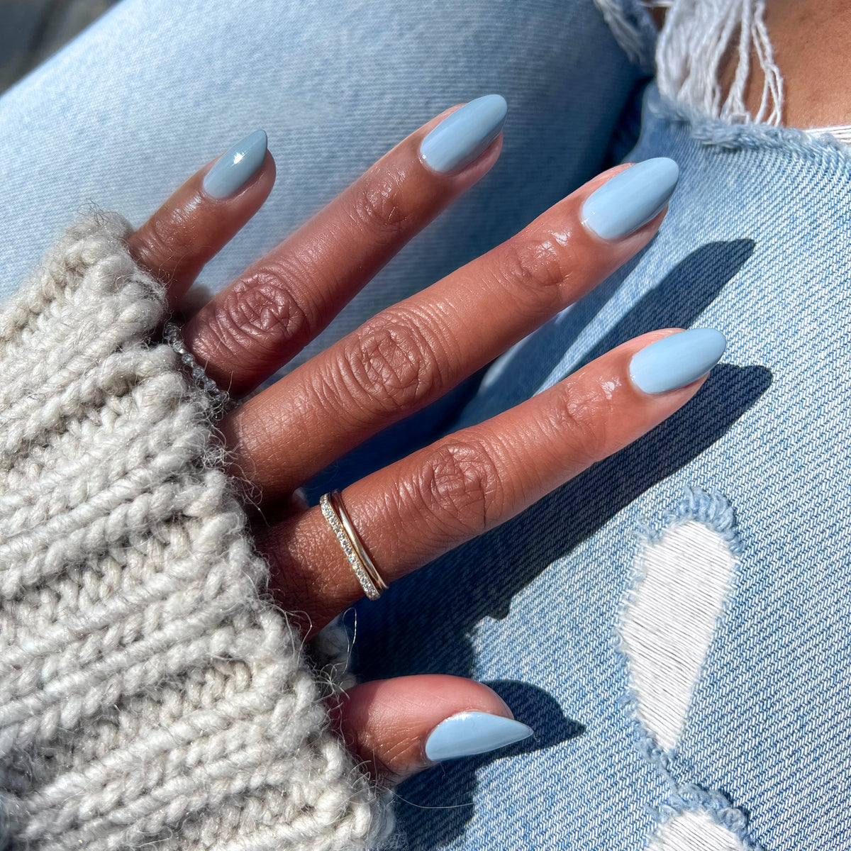 Close-up of hand with nails painted in Vintage blue polish for a smooth, long-lasting at-home manicure by Olive and June