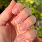 Fingernails with a natural glossy finish using Crystal clear polish in sunlight for a simple at-home manicure