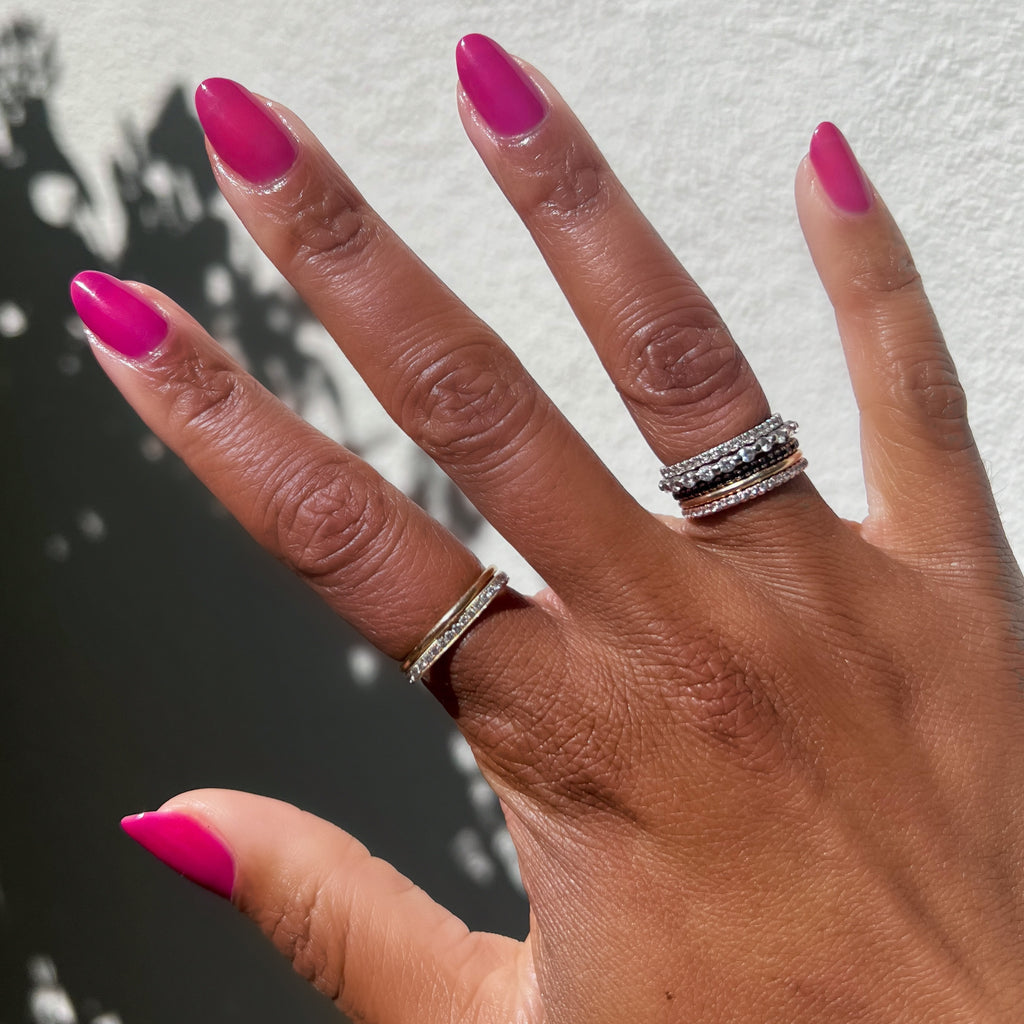 Hand with almond-shaped nails painted vibrant magenta-purple in This Lettuce is Radicchio long-lasting gel polish by Olive and June