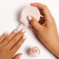 Hand using The Poppy universal polish handle to apply light pink nail polish for easier at-home mani control thumbnail