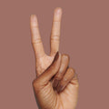 Hand with matte brown nails in a peace sign gesture featuring The Matte Top Coat for a smooth, durable manicure finish thumbnail