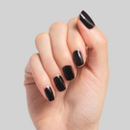 Close-up of hand with shiny black Cateye nail polish on nails against a neutral background for a sleek mani look