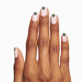 Hand with light pink polish and green snowflake designs using O&J Cozy Lodge Nail Art Stickers for winter manicures thumbnail
