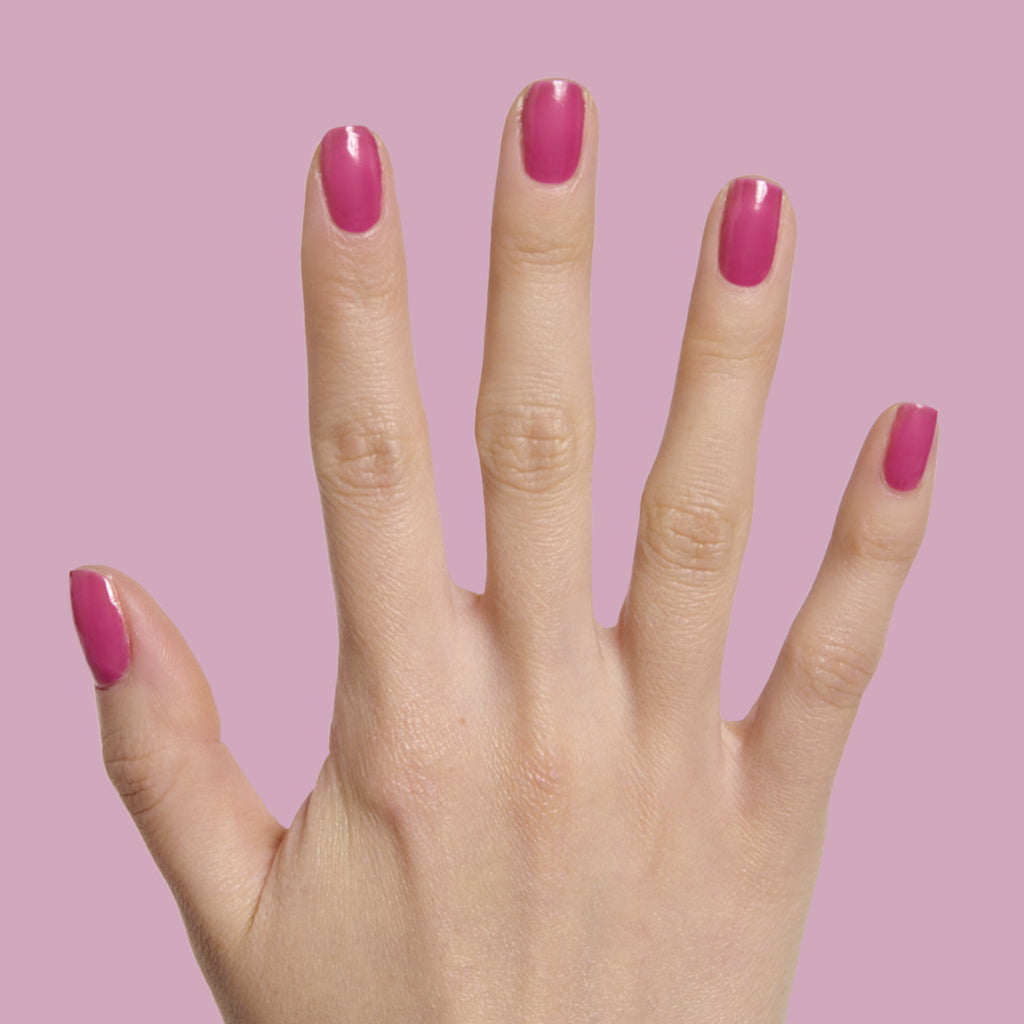Hand with nails painted in magenta purple shade from This Lettuce is Radicchio polish by Olive and June