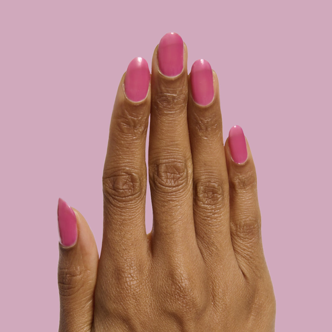 Hand with nails painted in sheer magenta-purple shade from This Lettuce is Radicchio nail polish by Olive and June