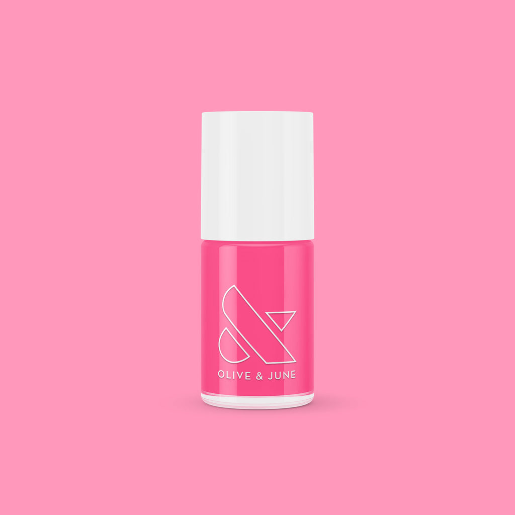 Olive and June Hot Strawberry gel polish bottle in bright strawberry pink against a matching pink background