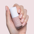 Hand holding Potpourri quick dry gel polish with nails painted in a sheer mauve neutral shade