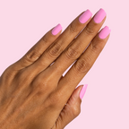 Hand with Taffy bright pink quick dry gel polish on neatly manicured nails against pale pink background