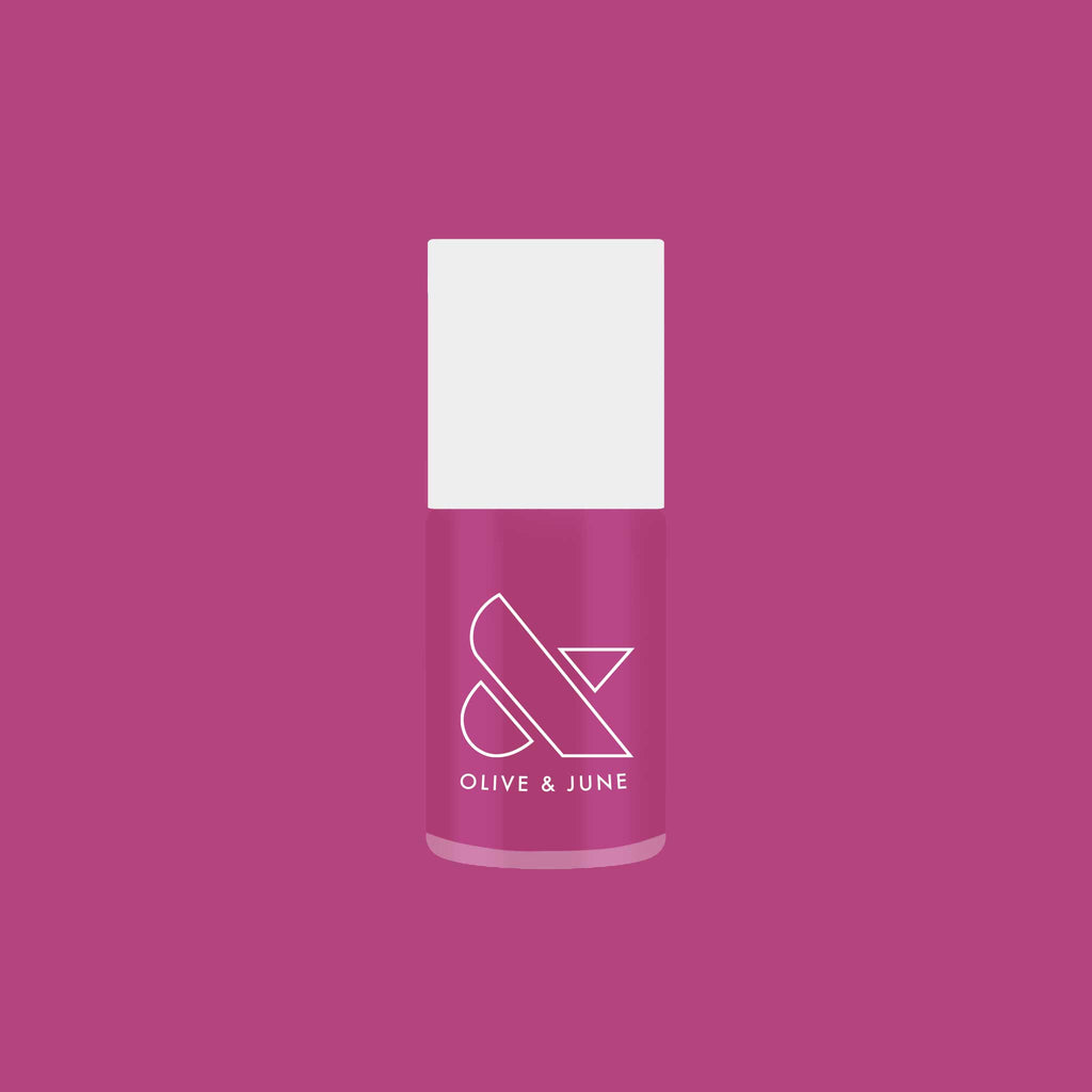 Bottle of Olive and June’s This Lettuce is Radicchio magenta-purple nail polish on matching background