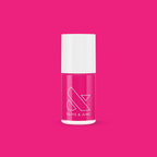Bottle of Olive and June WILD ORCHID nail polish in rich magenta purple against a vibrant pink background